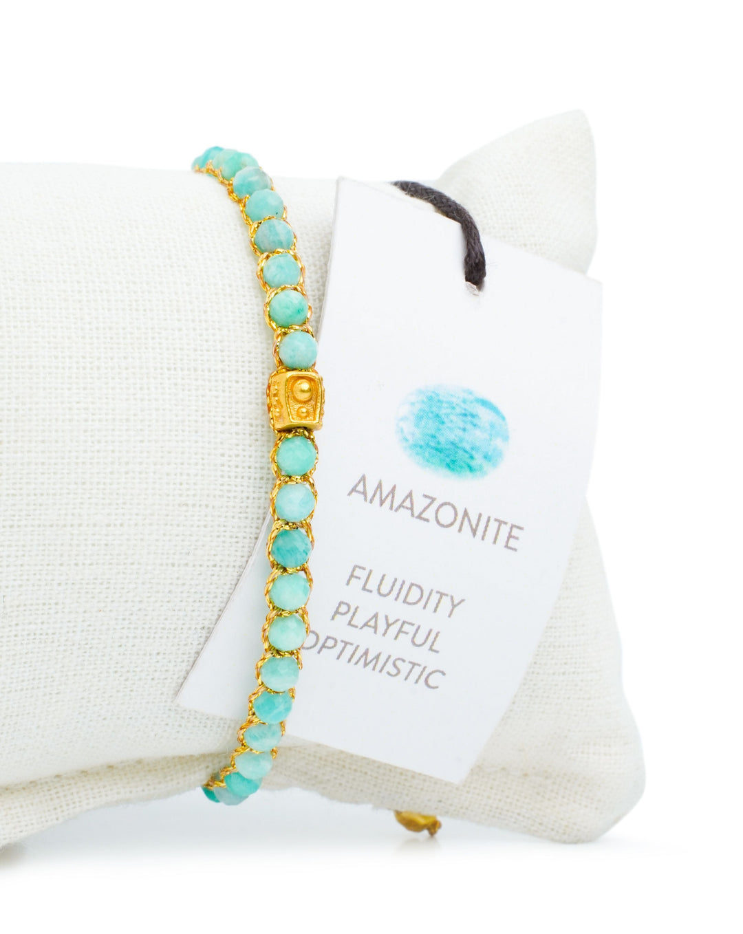 Amazonite Crystal Gemstone Adjustable bracelet covering white cushion strung together with 18K Gold Yarn, Information tag showing.