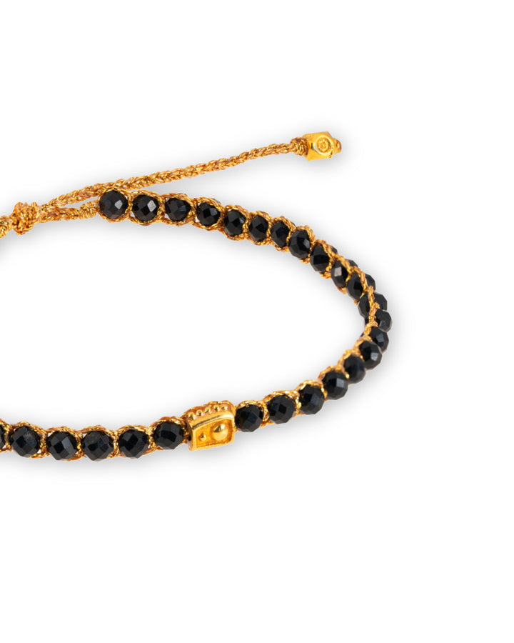 Black Spinel Gemstone Adjustable bracelet strung together with 18K Gold Yarn, close up view.