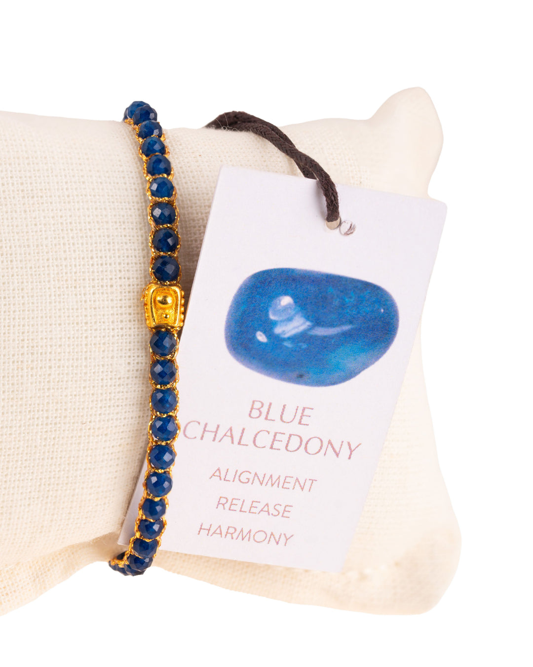 Blue Chalcedony Gemstone Adjustable bracelet covering white cushion strung together with 18K Gold Yarn, Information tag showing.