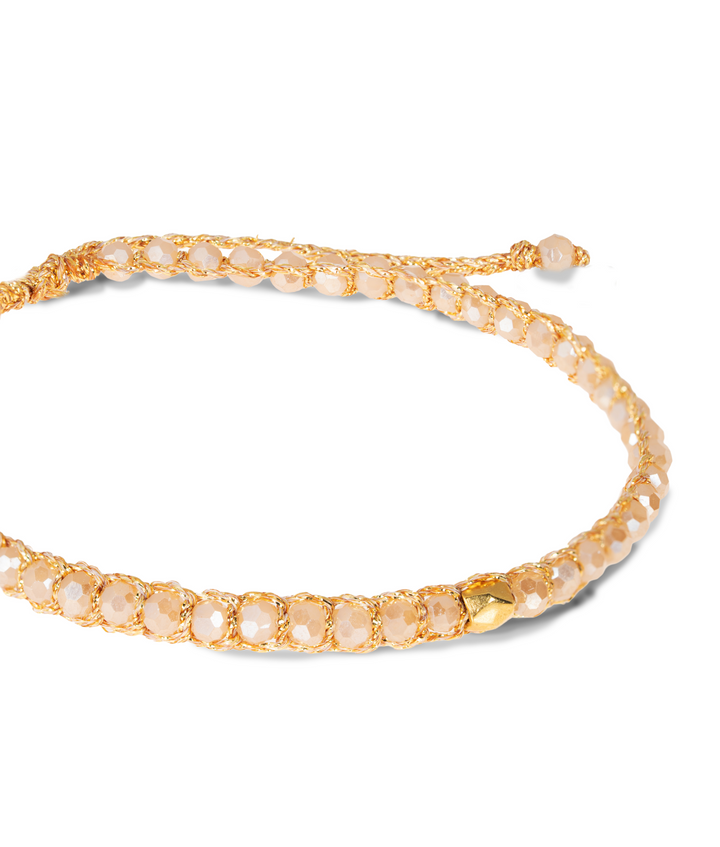 Gold bracelet with small crystal stones on a white background