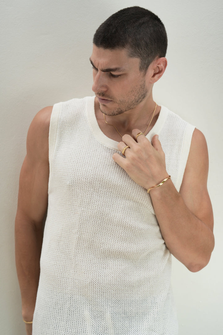 Founder of Nusands Corey Micari chest and head shot, look away to the right. Left hand to 18K Gold Roped in necklace, mirrored signet and six base rings on fingers, modest cuff on wrist.