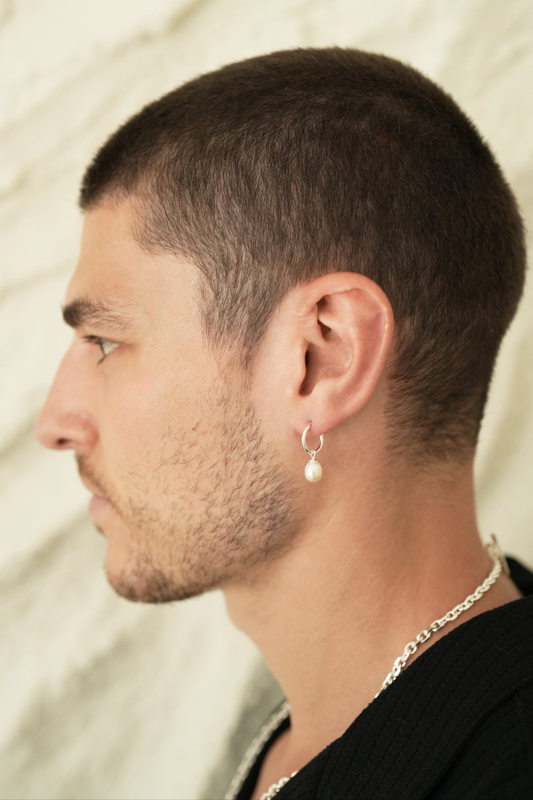 Founder of Nusands Corey Micari side profile wearing Sterling Silver hoop earring with removable pearl charm