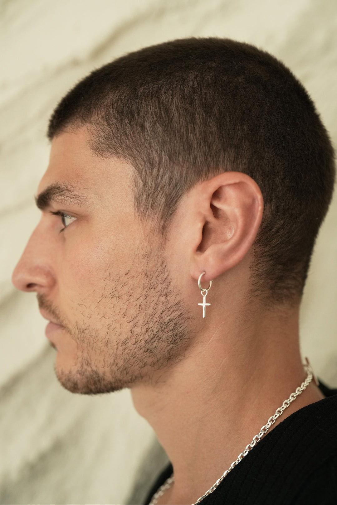 Founder of Nusands Corey Micari side profile wearing the sterling silver cross earring