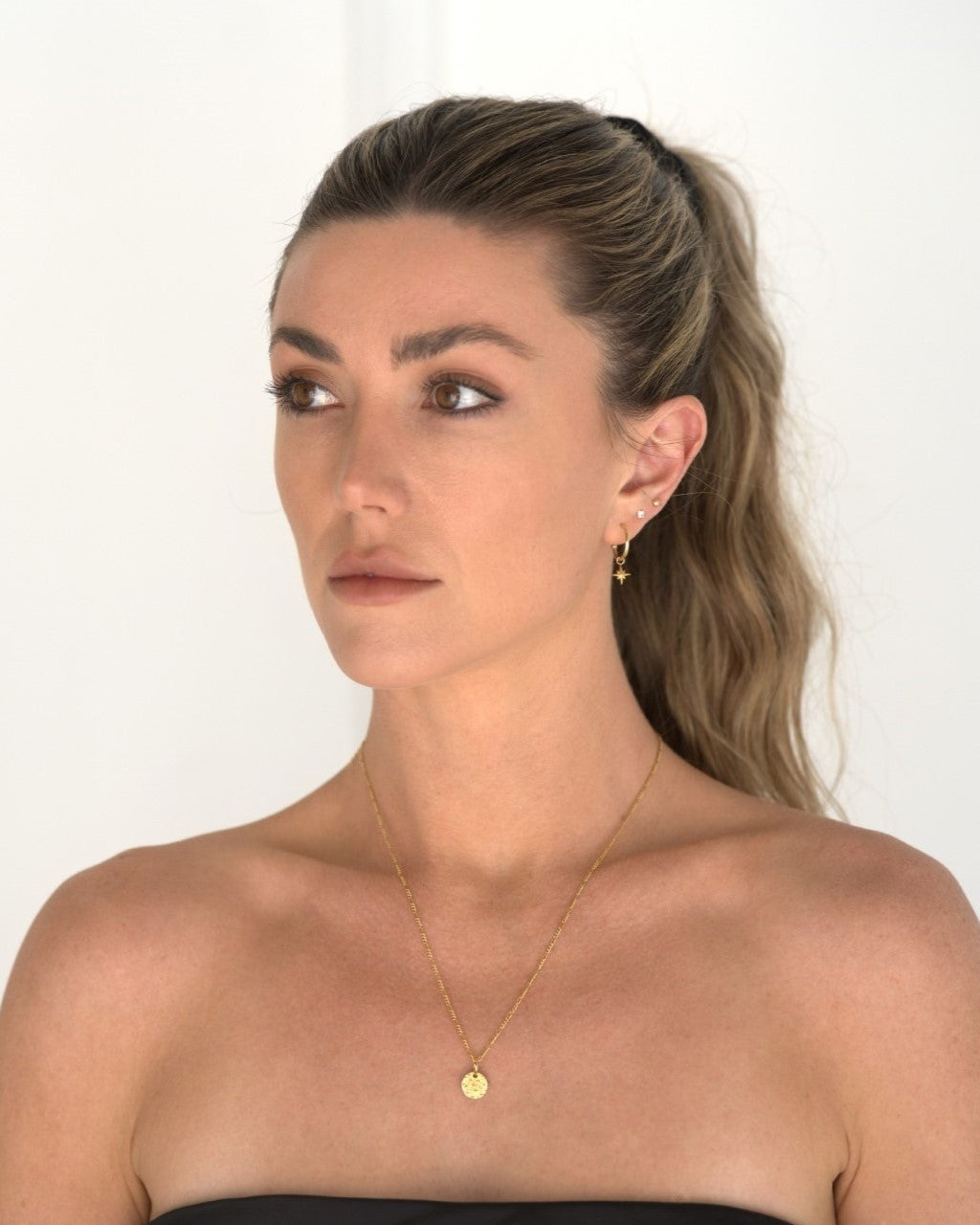 founder of Nusands Emily Micari front view, looking off to the right wearing the signature chain necklace in 18k gold with moon charm.
