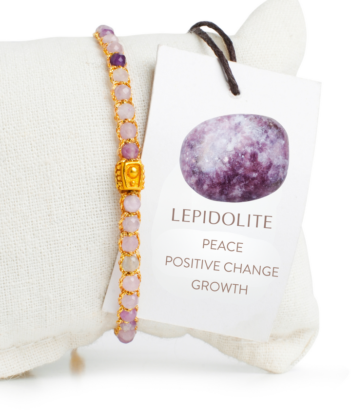 Lepidolite bracelet with gold accents on a white background