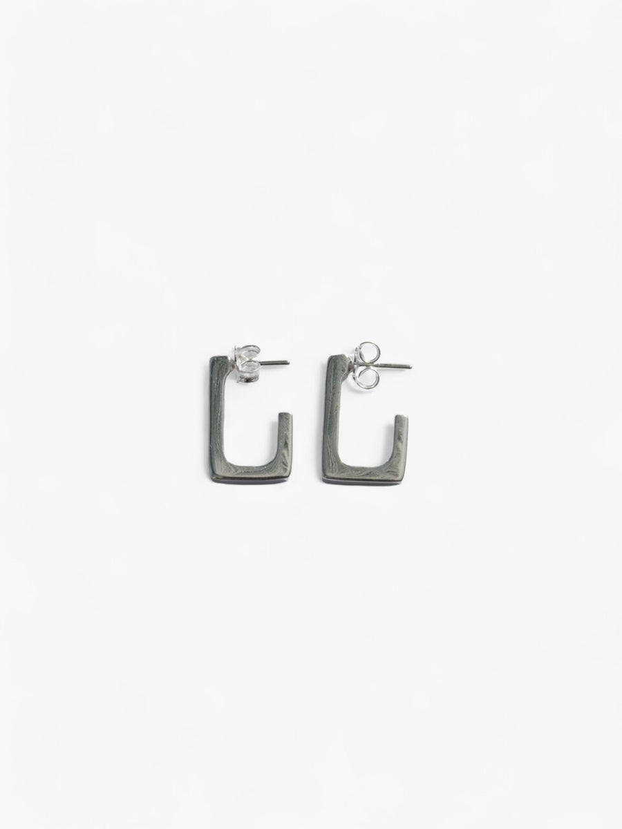 sterling silver rectangle open back earrings laying on their side