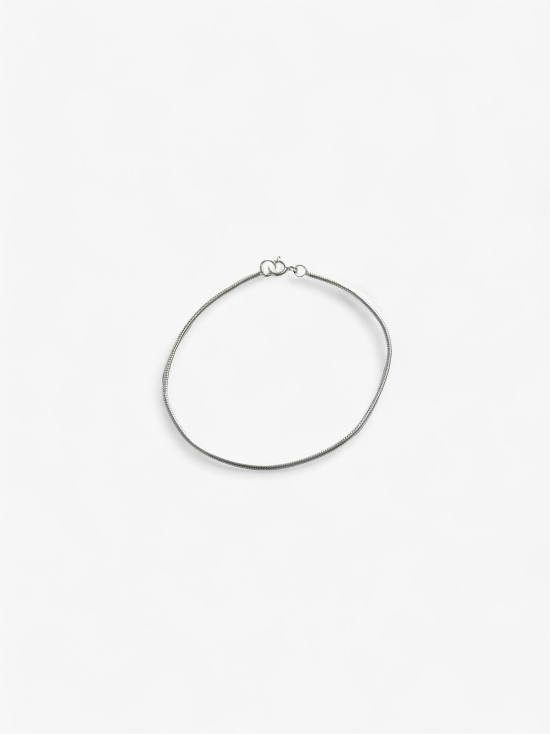 Thin Sterling Silver bracelet laid flat in a circle, clasped together.