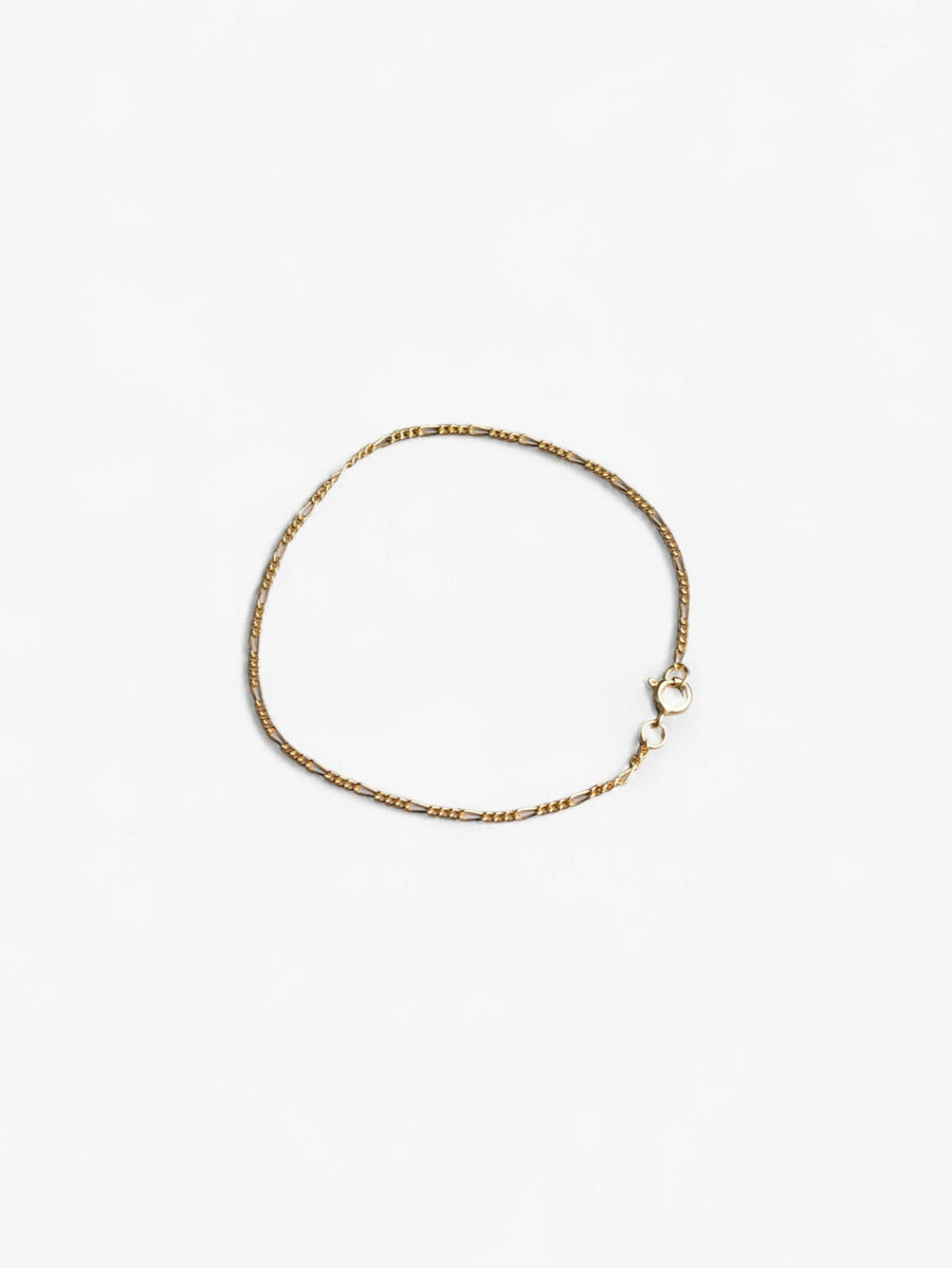 Thing 18K gold signature chain bracelet laying in a circle flat