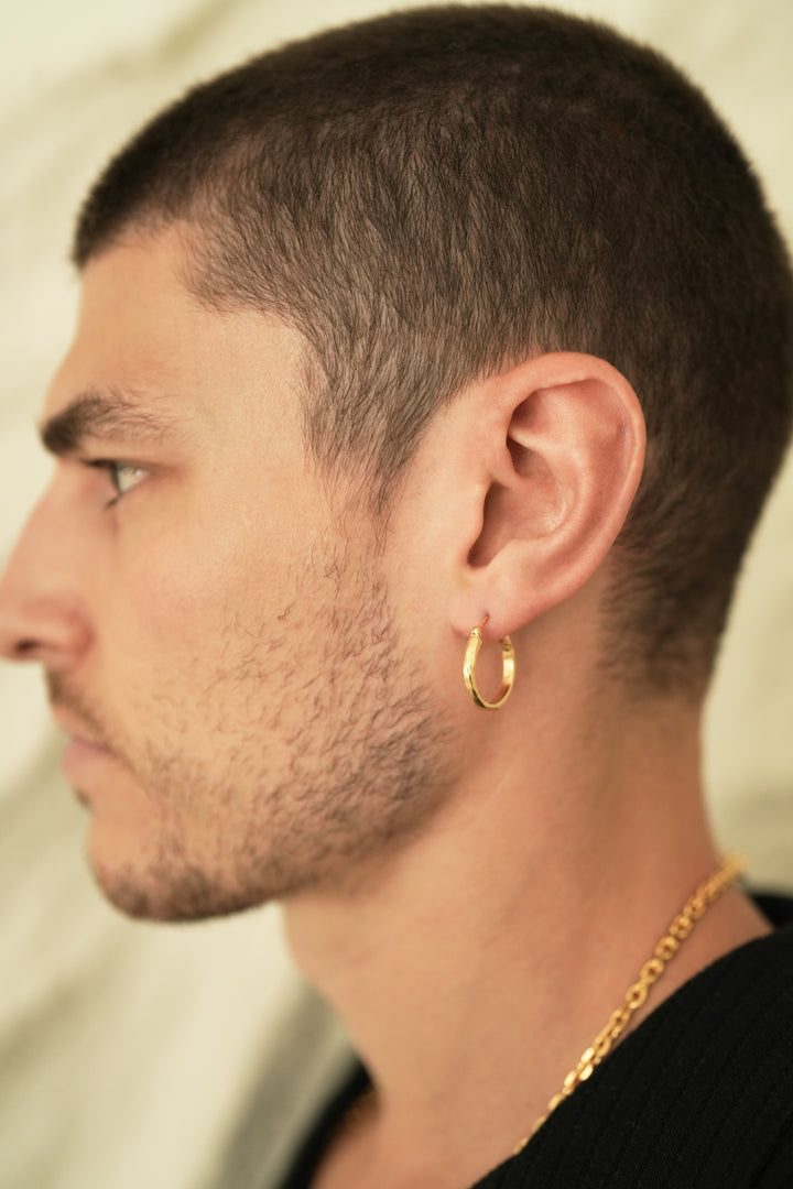 Founder of Nusands Corey Micari side profile wearing 18k gold wave earring in left ear.