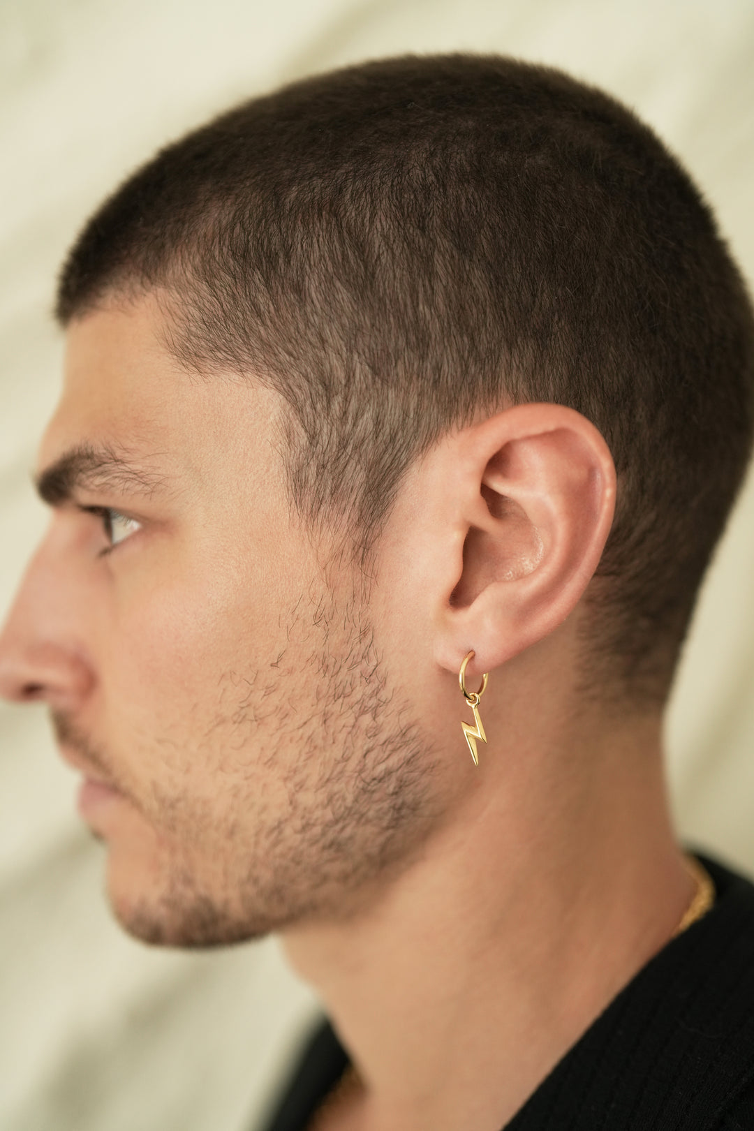 Founder of Nusands Corey Micari side profile wearing 18k gold lightning bolt earring