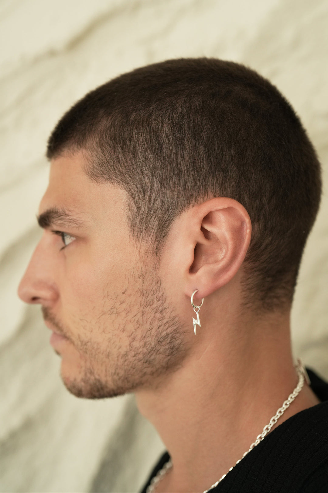 Founder of Nusands Corey Micari side profile wearing sterling silver lightning bolt earring