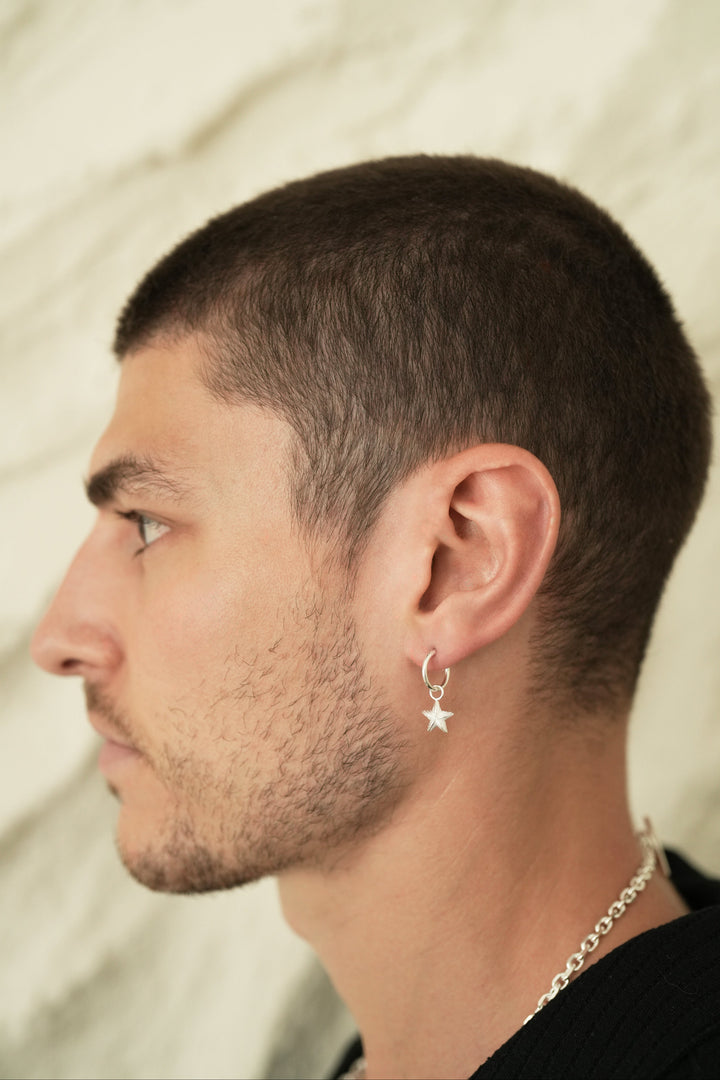 Founder of Nusands Corey Micari side profile wearing sterling silver round hoop earring with removable star charms.