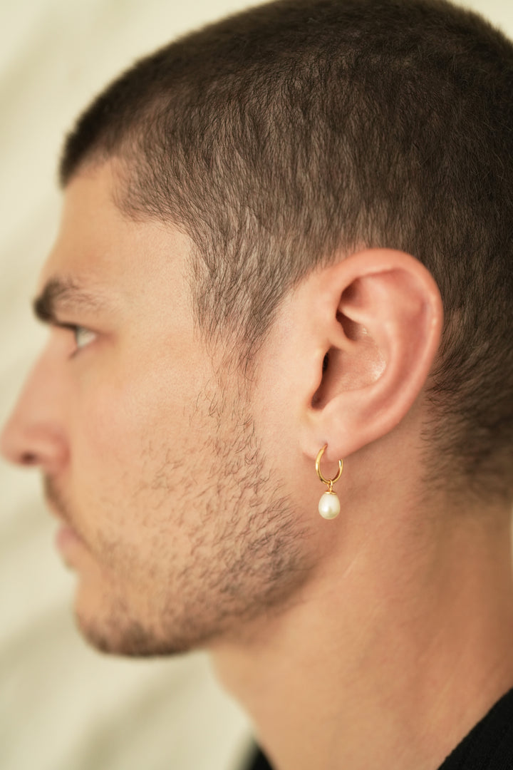 Founder of Nusands Corey Micari side profile wearing 18k Gold hoop earrings with removable pearl charms