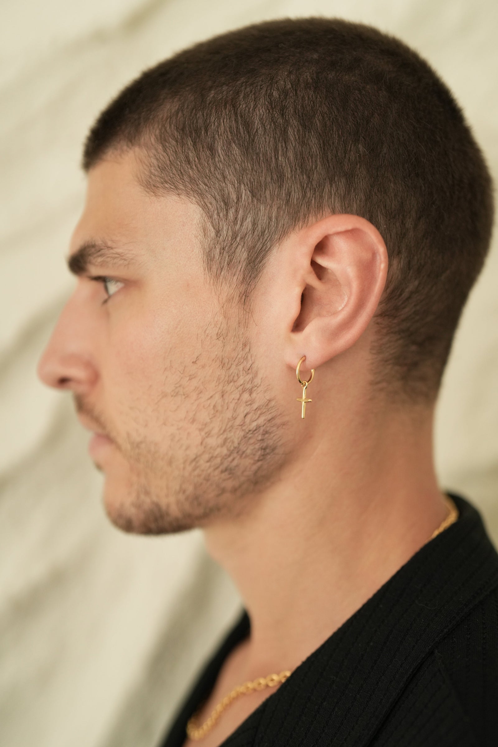 Founder of Nusands Corey Micari side profile wearing the 18K Gold cross earrings