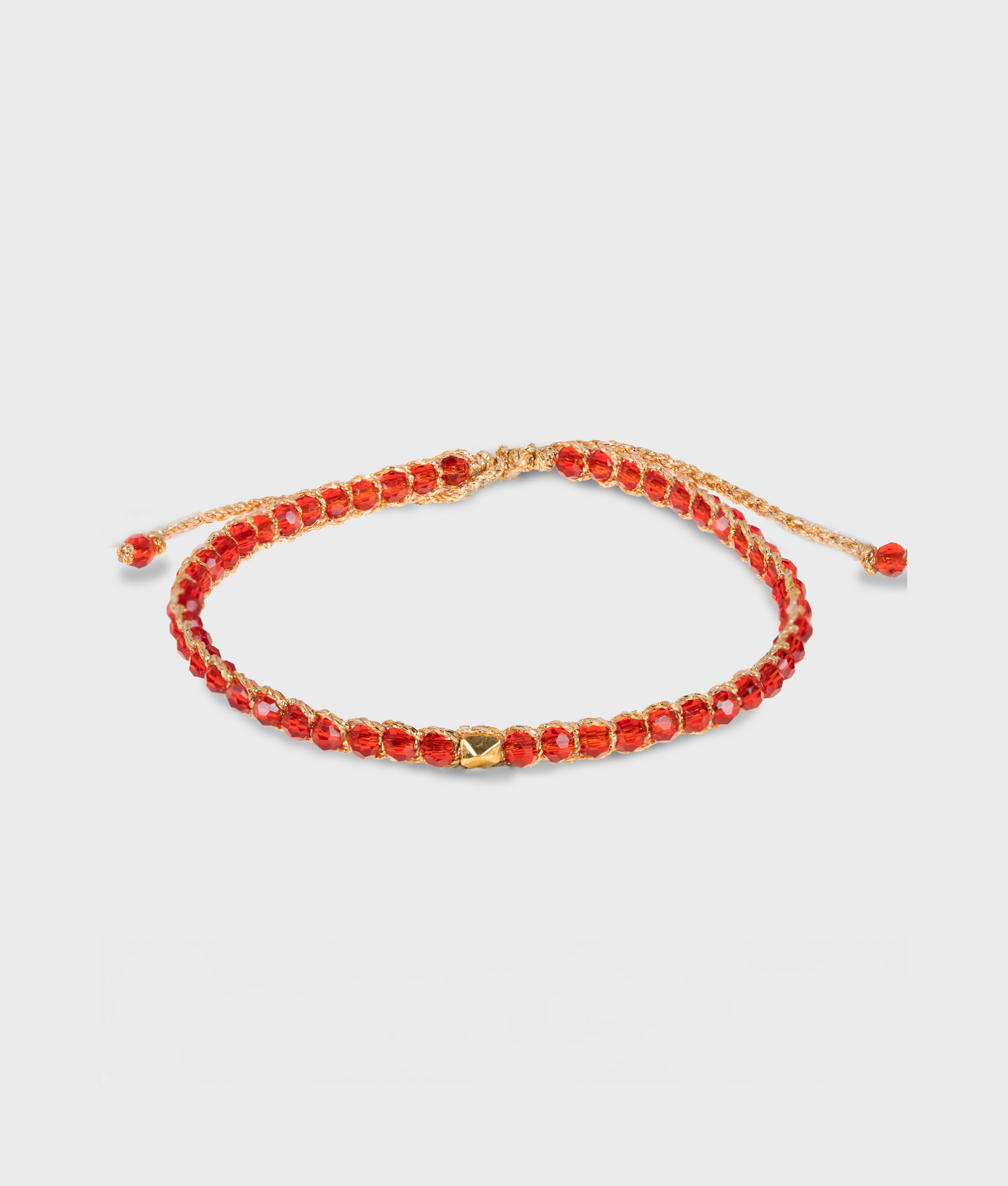 Red beaded bracelet with gold clasp on a light gray background