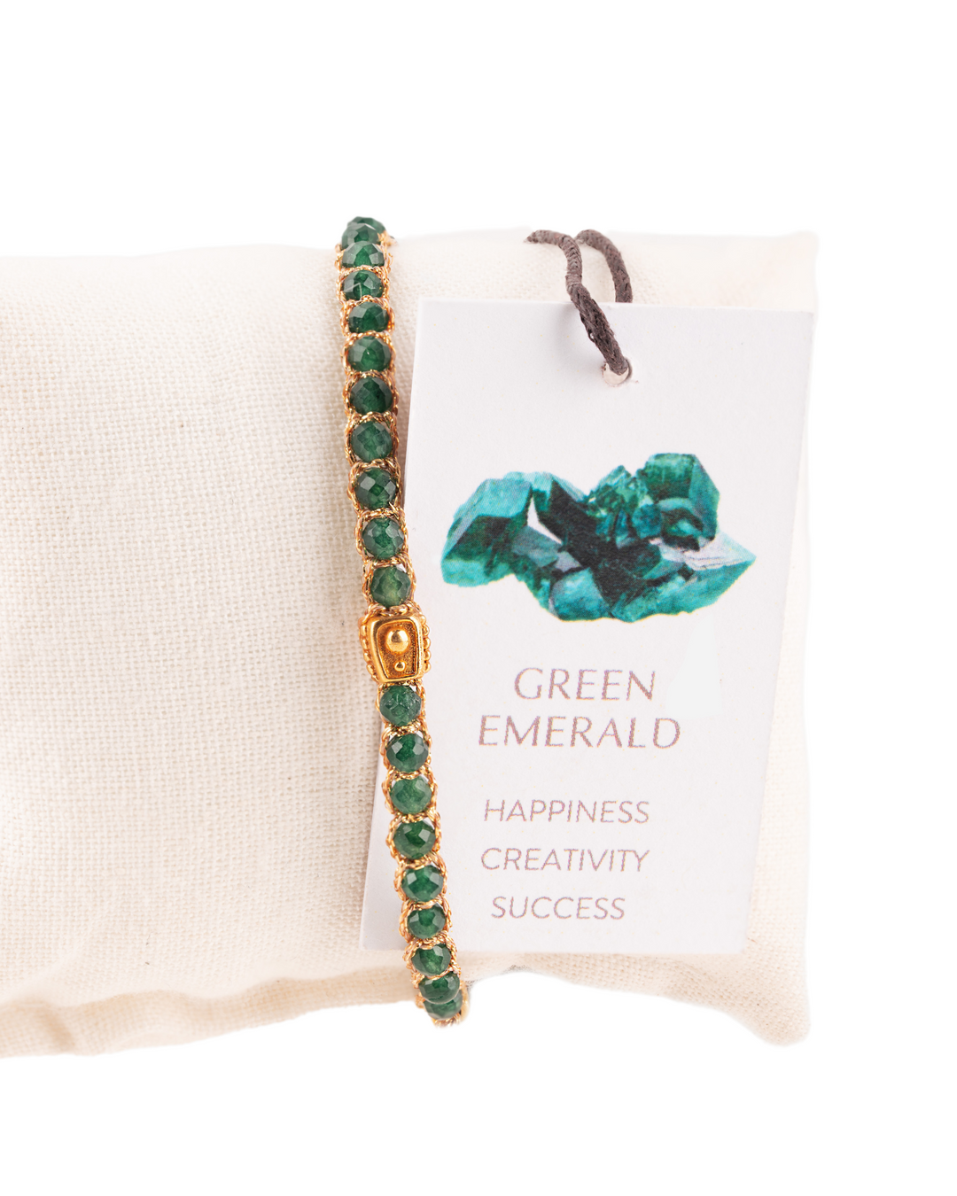 Green Emerald Crystal Gemstone Adjustable bracelet covering white cushion strung together with 18K Gold Yarn, Information tag showing.