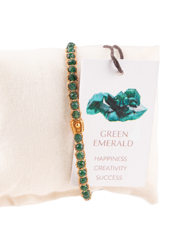Green Emerald Crystal Gemstone Adjustable bracelet covering white cushion strung together with 18K Gold Yarn, Information tag showing.