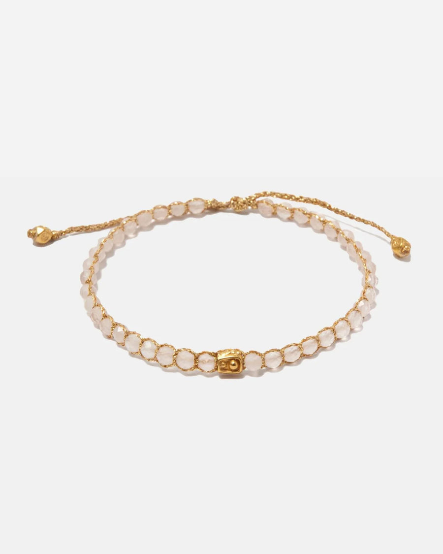 Madagascar Rose Quartz crystal bracelet with adjustable gold yarn clasp on a white background
