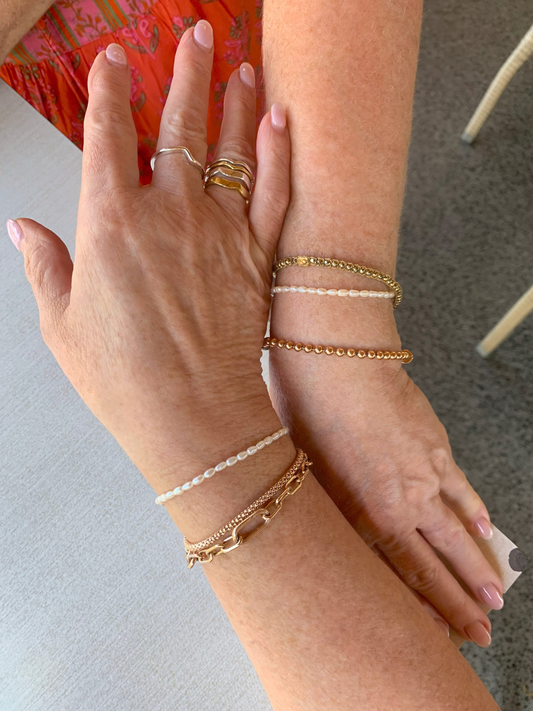Close-up of hands wearing Nusands pearl bracelet paired with gemstone bracelet