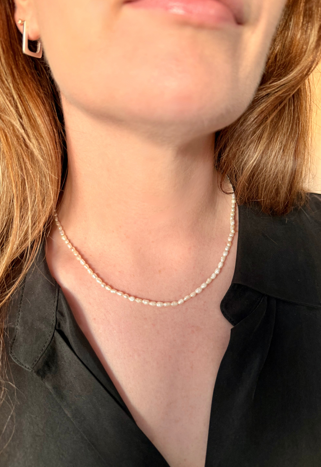 Close up of a woman wearing Nusands pearl choker necklace
