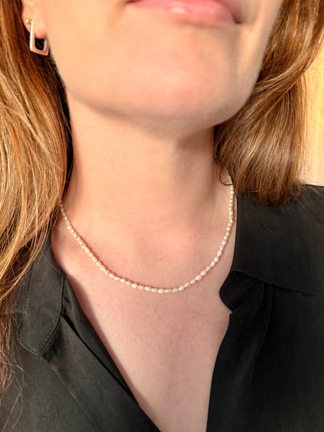 Close-up of a person wearing Nusands pearl choker necklace