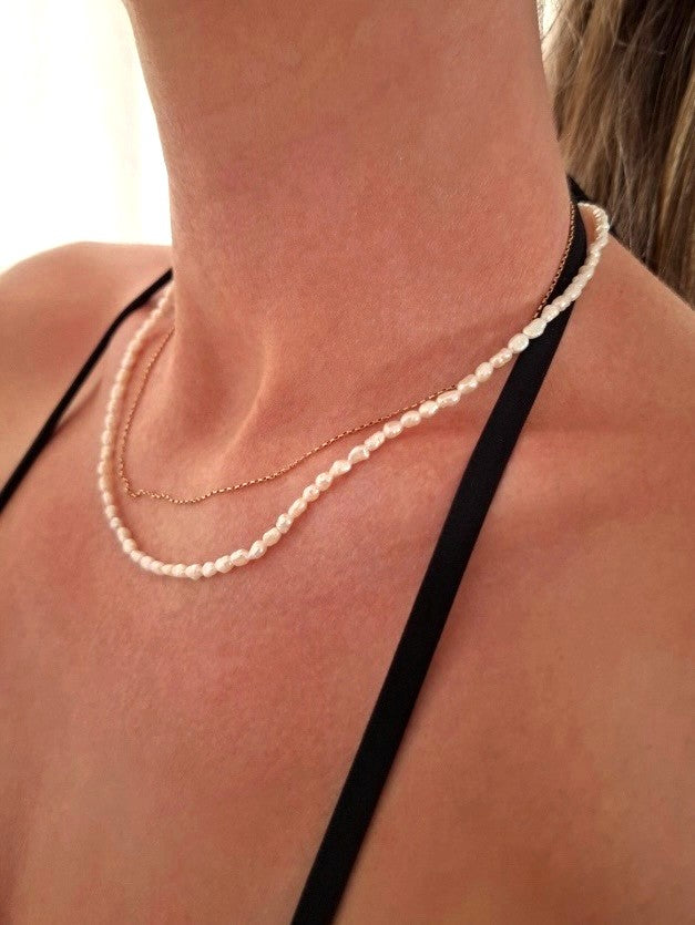 Emily wearing dainty sterling silver fresh water Pearl Necklace around her neck, zoomed in on her neck.