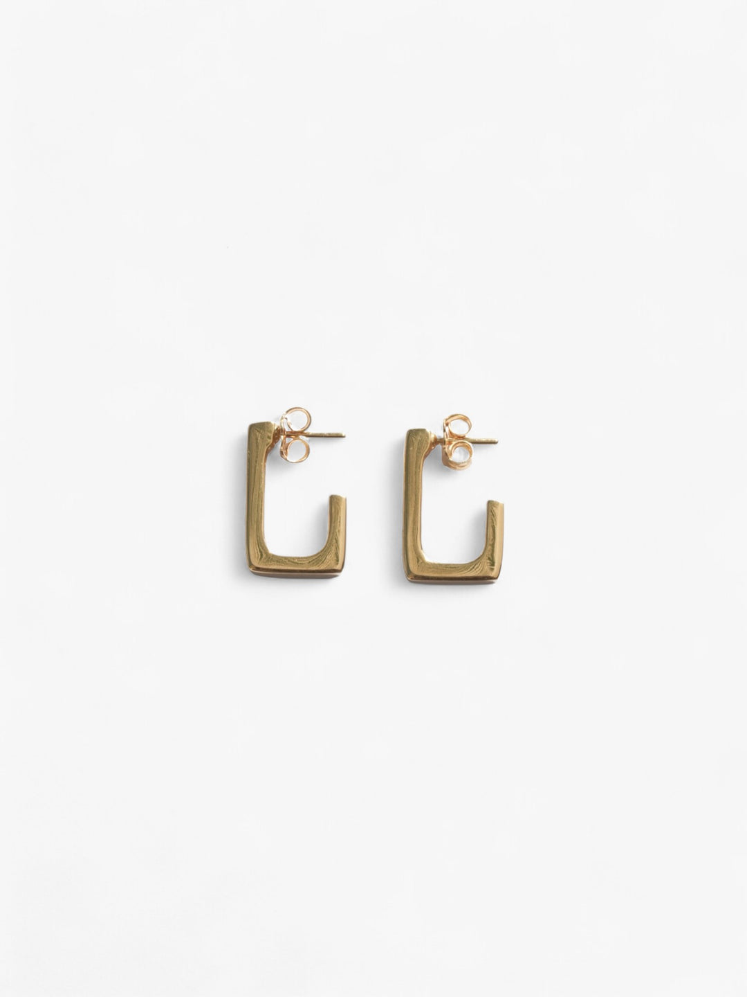 18k gold open back rectangle earrings laid on their side.