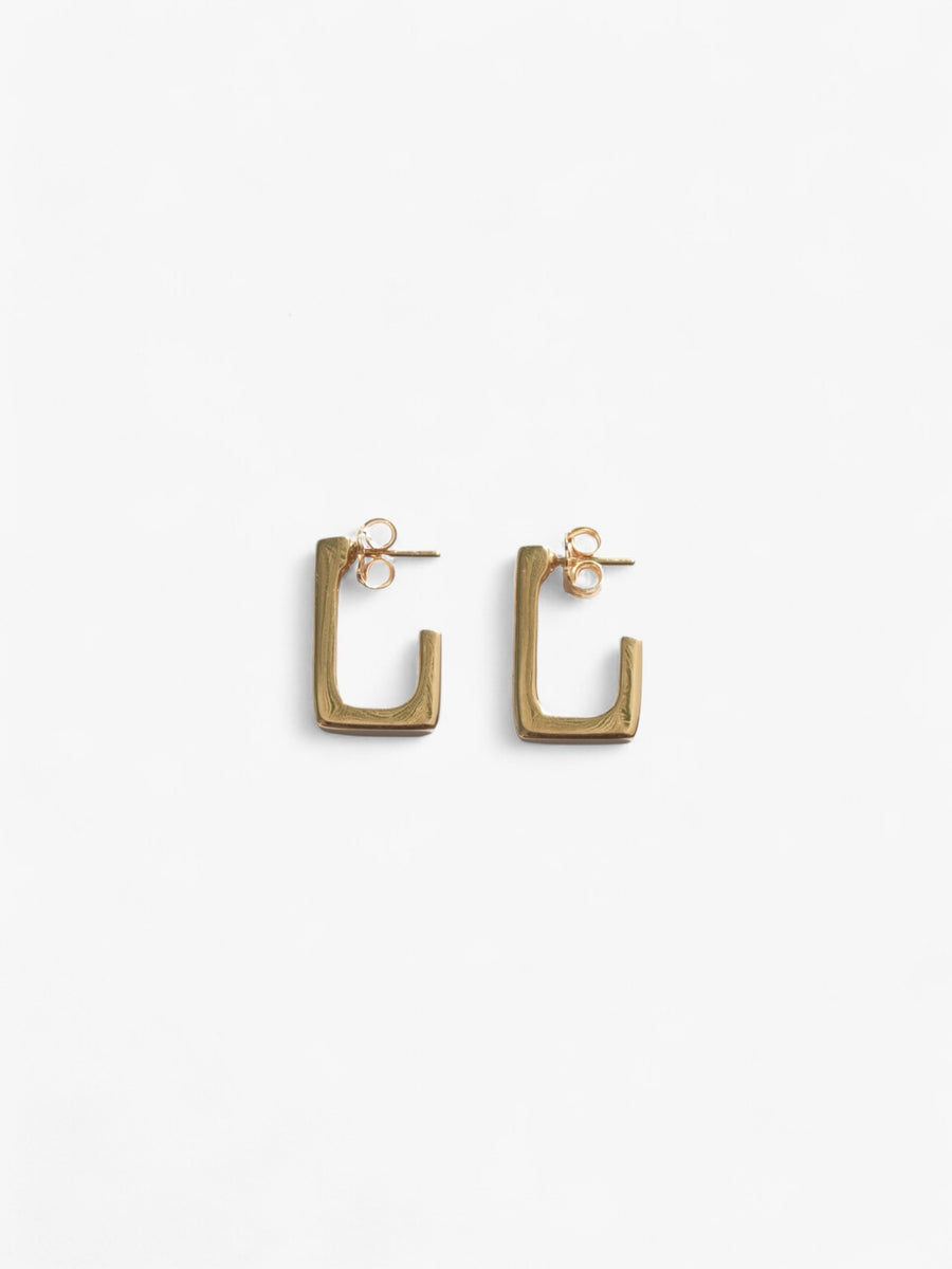 18k gold open back rectangle earrings laid on their side.