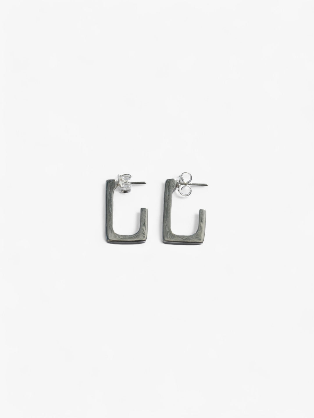 sterling silver rectangle open back earrings laying on their side