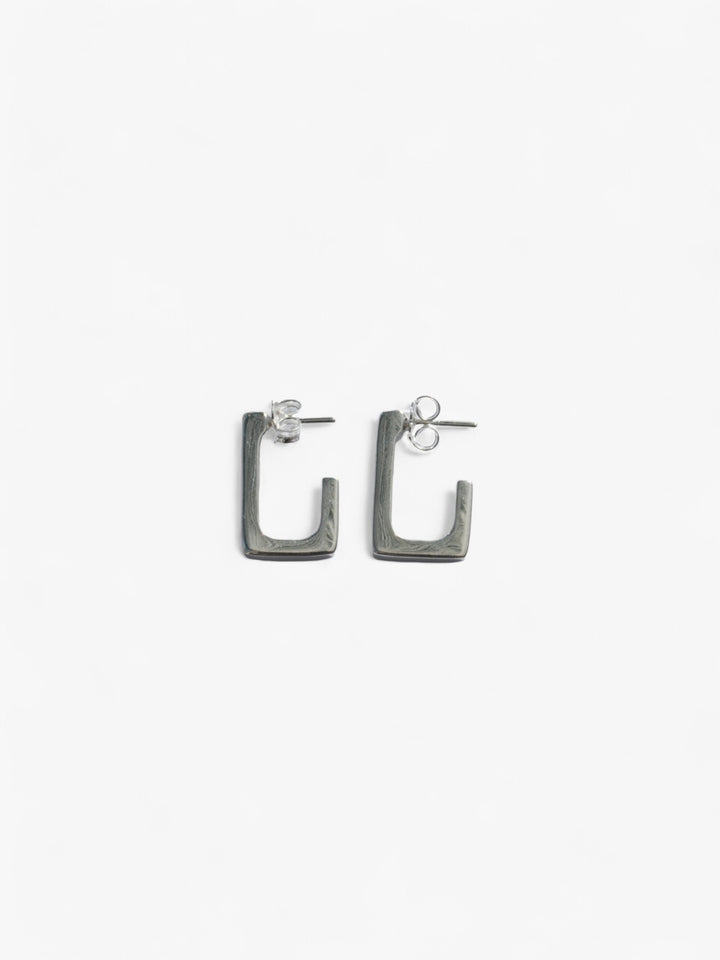 sterling silver rectangle open back earrings laying on their side