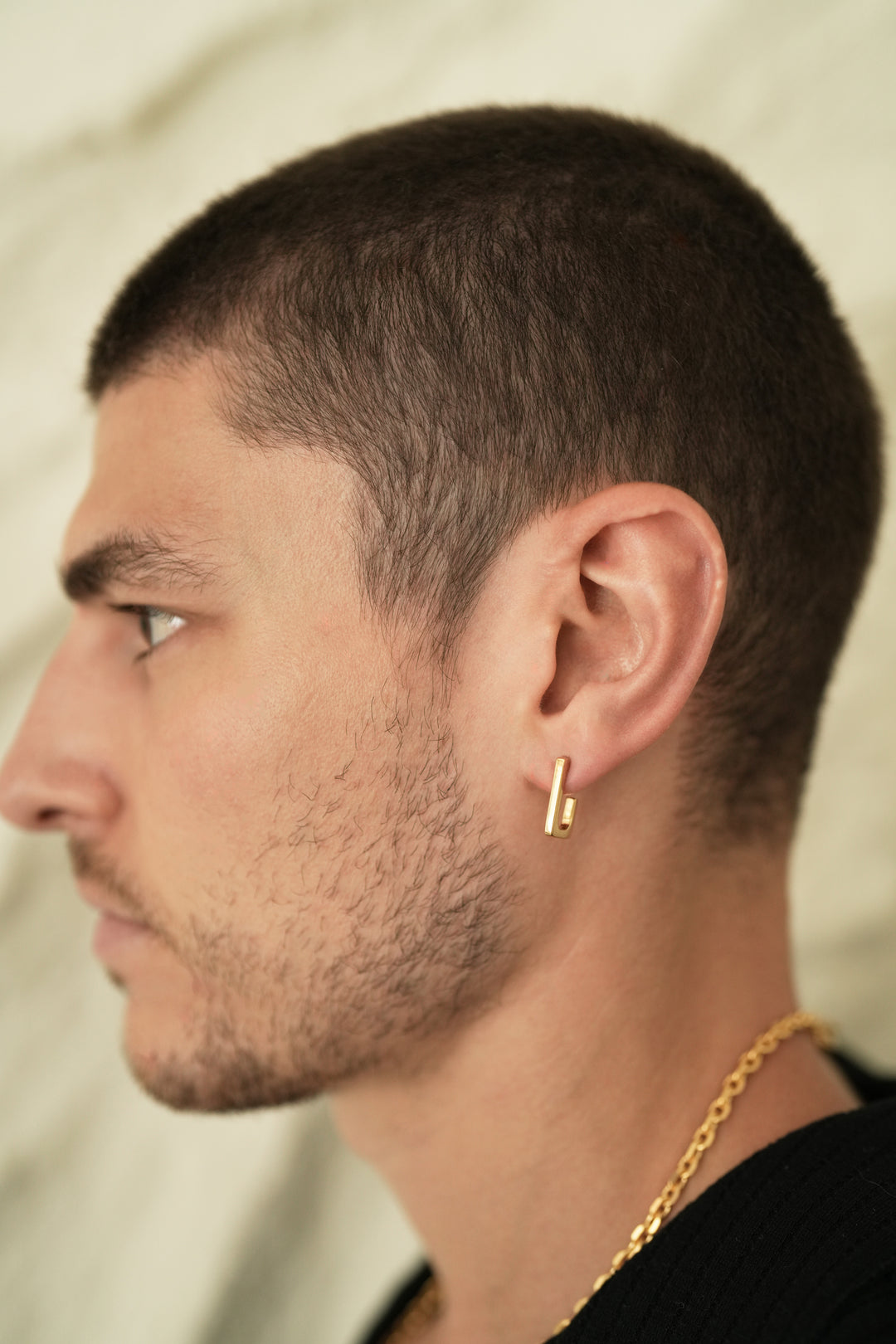 Founder of Nusands Corey Micari side profile wearing 18K gold rectangle earring