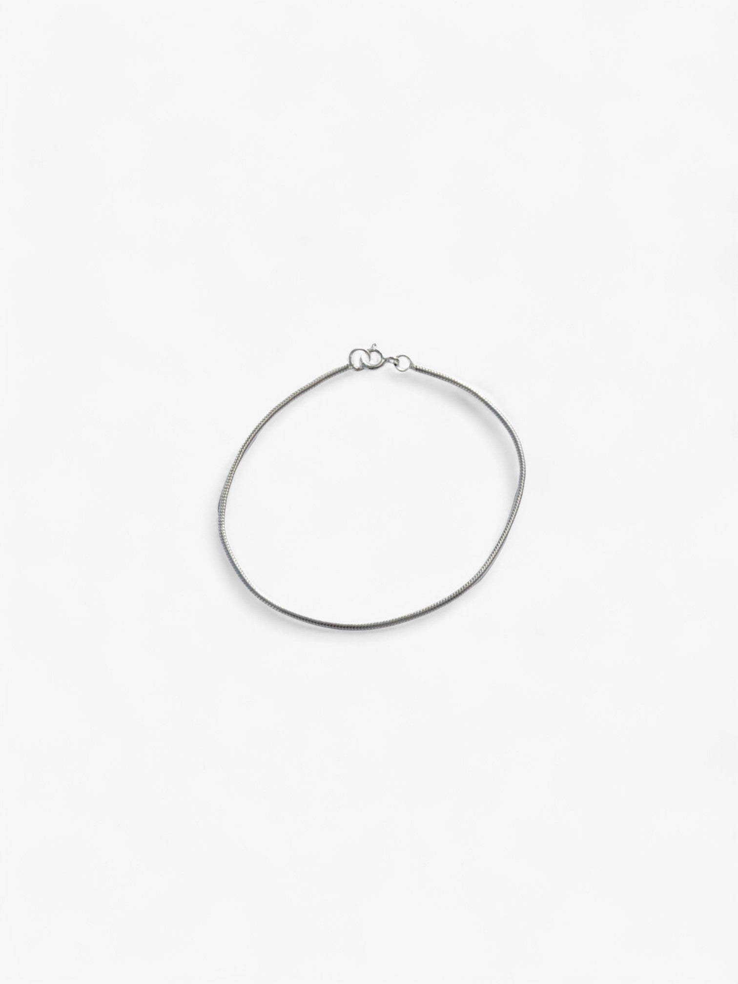 Thin Sterling Silver bracelet laid flat in a circle, clasped together.