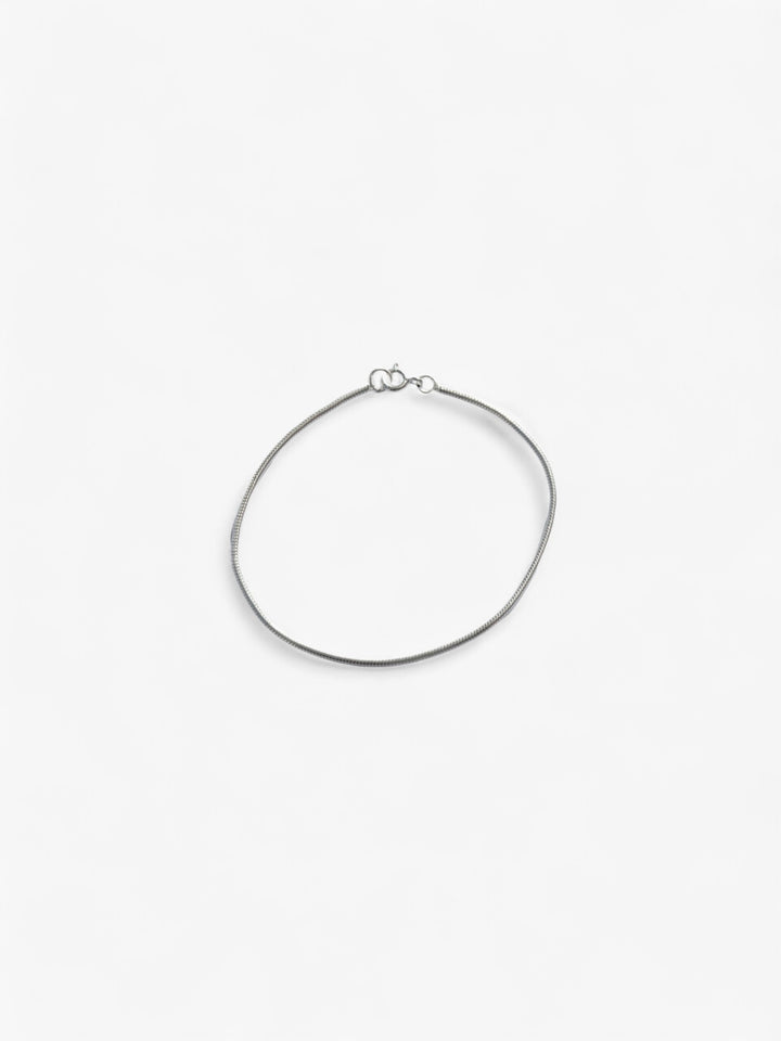 Thin Sterling Silver bracelet laid flat in a circle, clasped together.