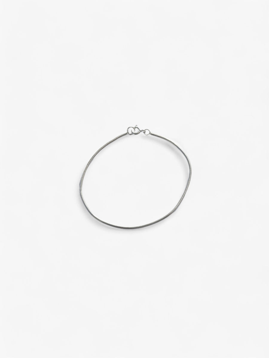 Thin Sterling Silver bracelet laid flat in a circle, clasped together.