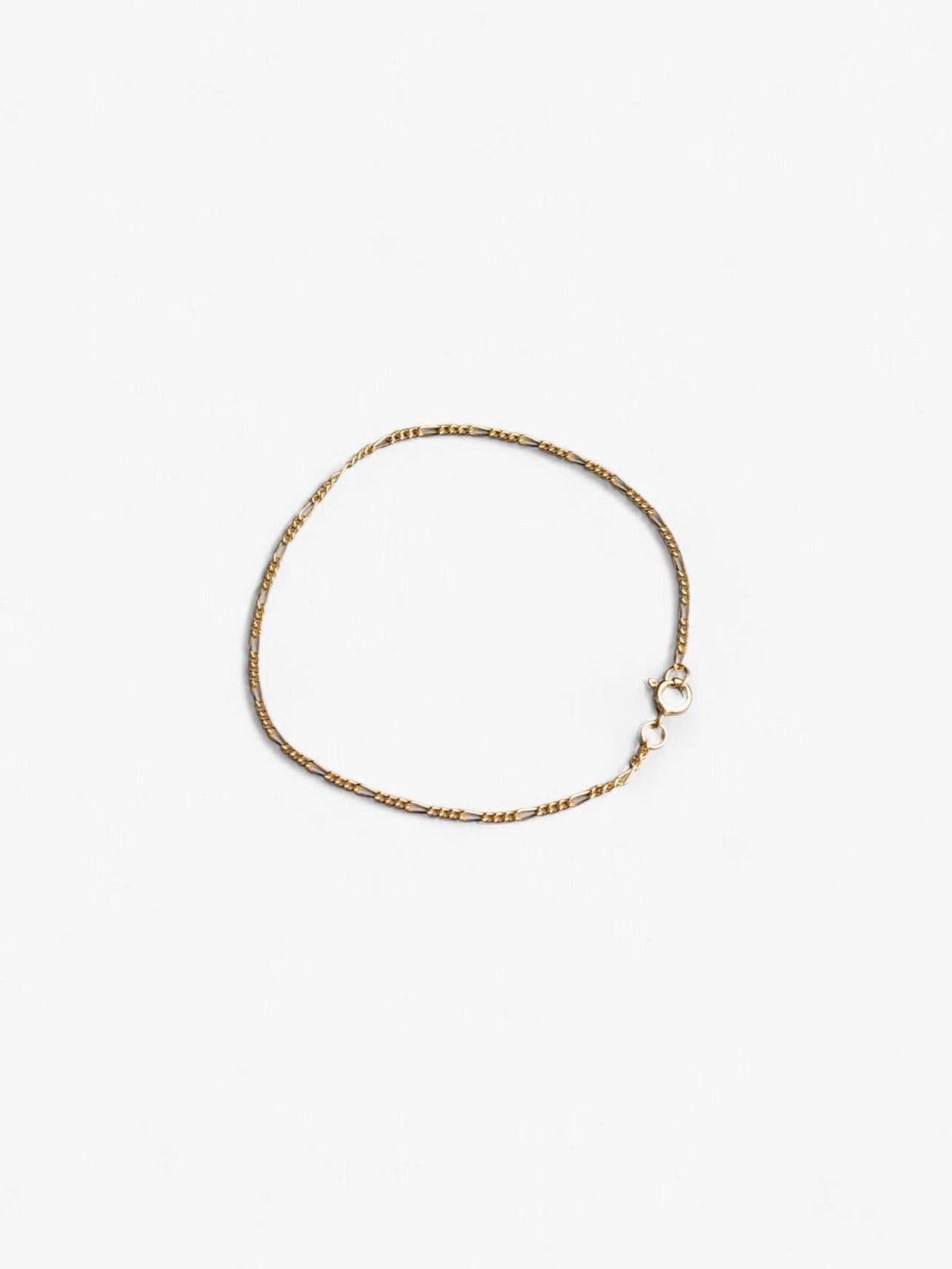 Thing 18K gold signature chain bracelet laying in a circle flat