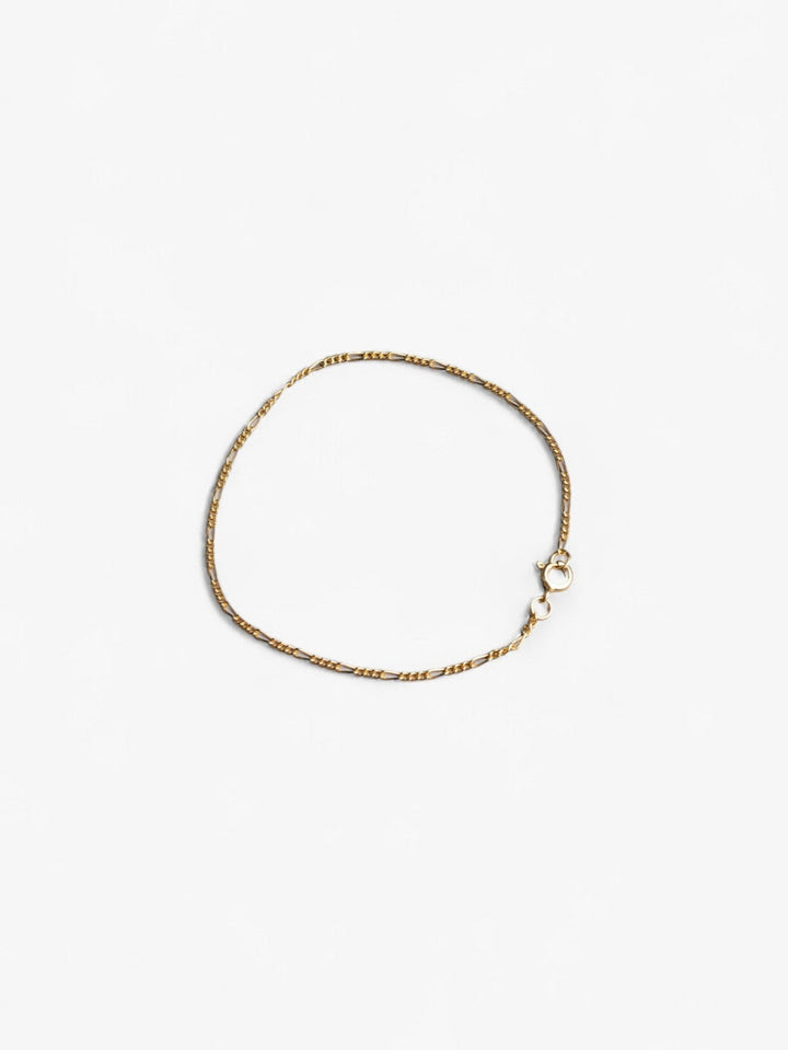 Thing 18K gold signature chain bracelet laying in a circle flat