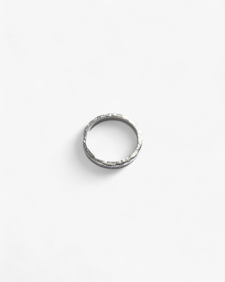 Round Shiny Sterling Silver stacker ring, hammered finished laying flat.