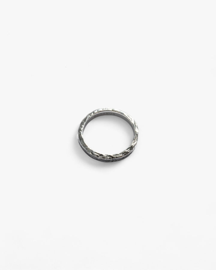 Round Sterling Silver oxidised stacker ring, hammered finished laying flat.