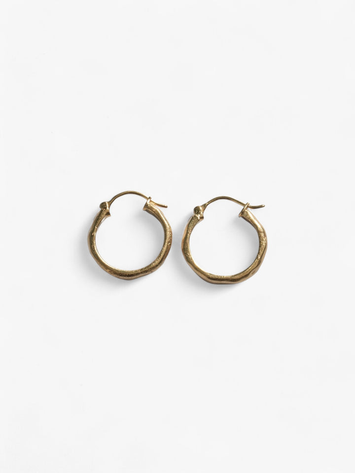 Chunky pair of 18k Gold wavy hoop earrings next to each other