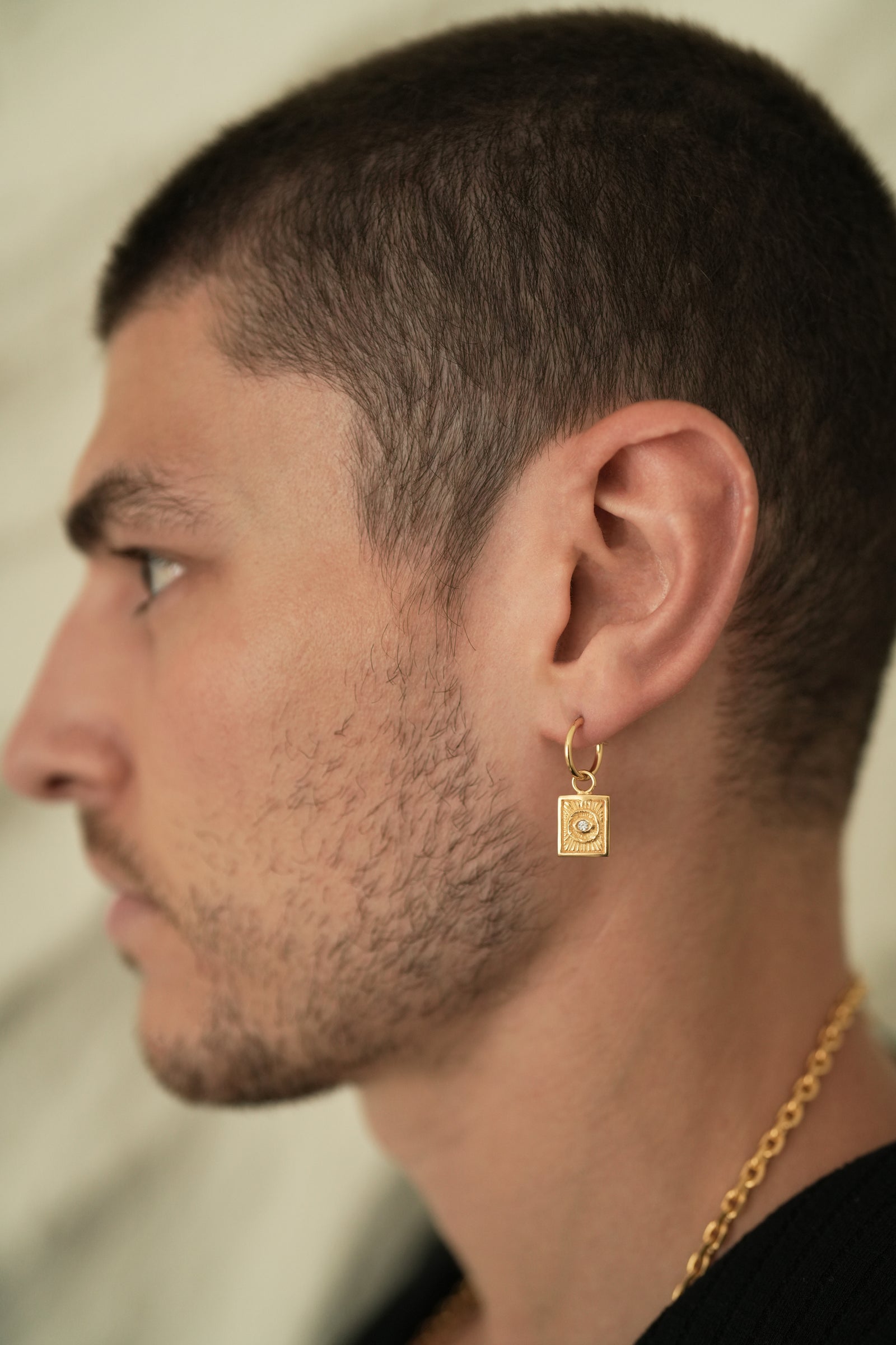 Founder of Nusands Corey Micari side profile wearing the 18K Gold evil eye earring