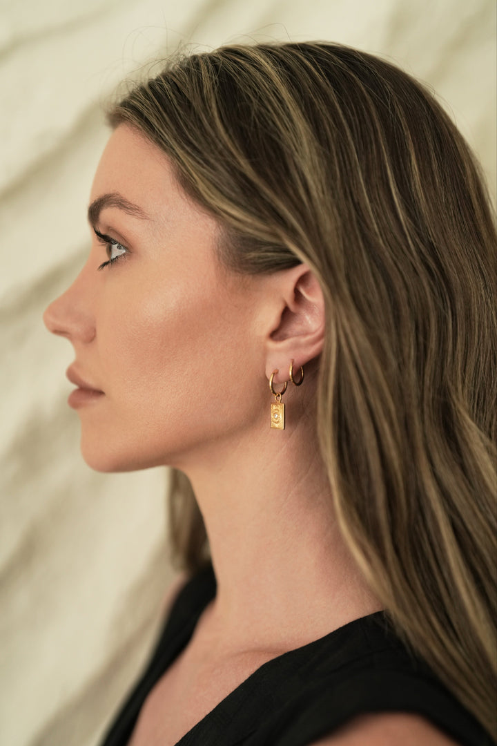 Founder of Nusands Emily Micari side profile wearing the 18K Gold evil eye earring