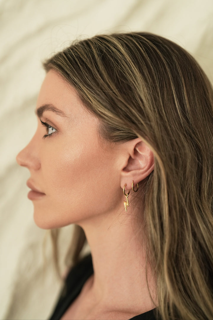 Founder of Nusands Emily Micari side profile wearing 18k gold lightning bolt earring