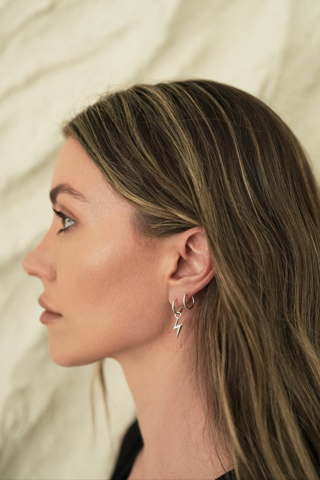 Founder of Nusands Emily Micari side profile wearing sterling silver lightning bolt earring