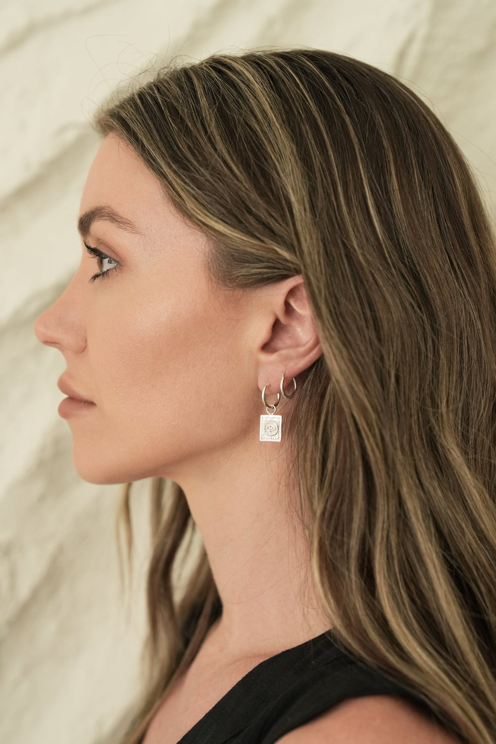 Founder of Nusands Emily Micari side profile wearing the sterling silver evil eye earring